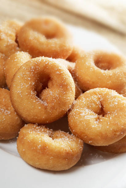istock Mini sugar coated doughnuts piled on a white plate. 1167925705