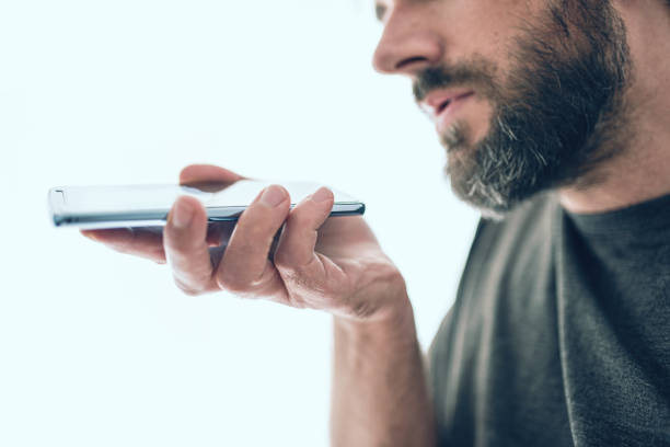Rear view of a business man speaking over cellphone against white
