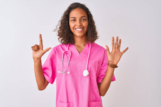 junge brasilianische krankenschwester frau trägt stethoskop stehen dopen über isolierten weißen hintergrund zeigt und zeigt mit den fingern nummer sieben, während lächelnd zuversichtlich und glücklich. - male nurse fotos stock-fotos und bilder