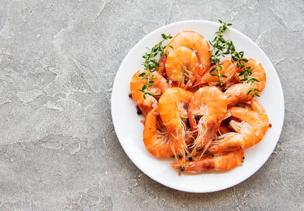 Shrimps on a plate Shrimps in plate on a grey concrete background prawn seafood stock pictures, royalty-free photos & images