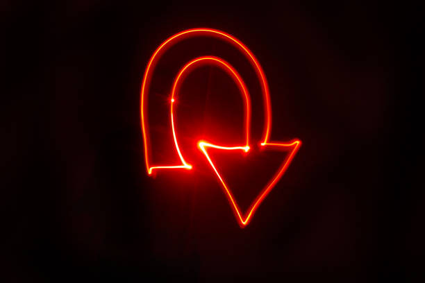 U turn arrow bright red light painting. Studio shot with a black background. Drawn with red LED lights.