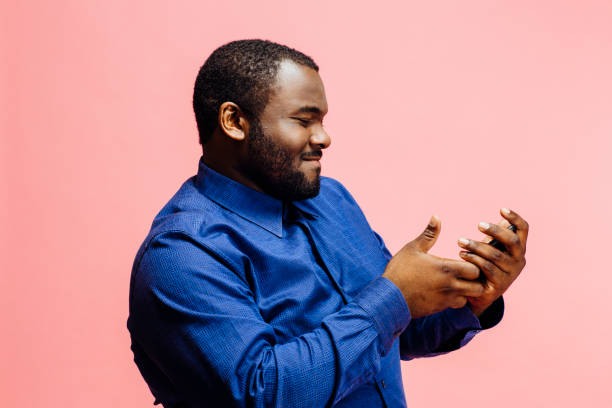 portrait of a man in blue shirt checking his phone - portrait human face men overweight imagens e fotografias de stock