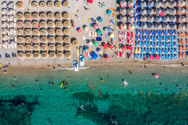 vue aérienne de plage d'émeraude bordée de bouées à côté d'une longue plage remplie de parasols et de transats - mushroom edible mushroom water splashing photos et images de collection