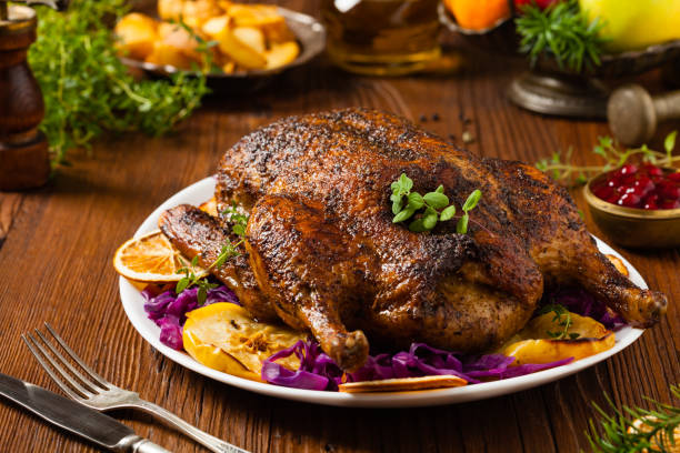 istock Baked whole duck, served with apples, red cabbage, oranges and roasted fritters. 1167932836