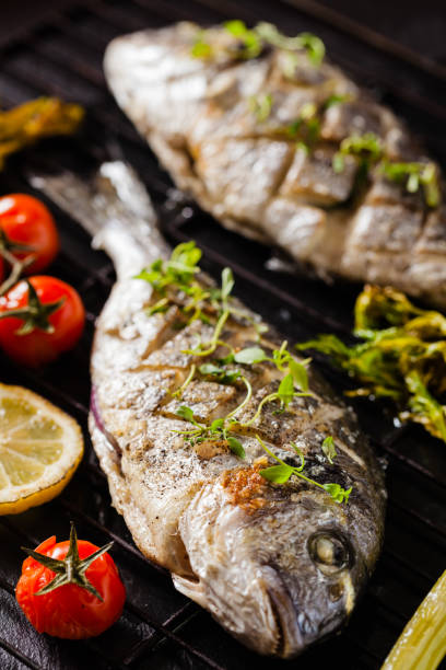 istock Grilled whole fish, served with roasted vegetables and lemon. 1167933583
