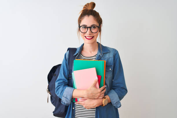 redhead student indatus mit rucksack mit büchern über isoliertem weißen hintergrund mit einem glücklichen gesicht stehend und lächelnd mit einem selbstbewussten lächeln mit zähnen - toothy smile relaxation white healthcare and medicine stock-fotos und bilder