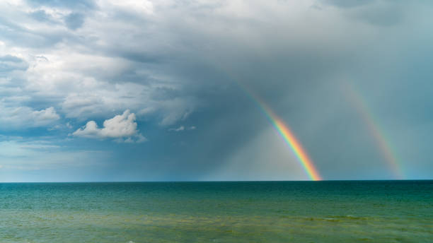istock rainbow over the blue sea, seascape as background 1167937512