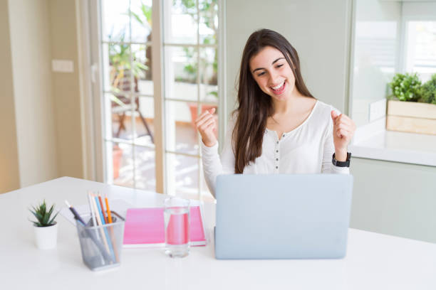 istock Beautiful young student woman studying for university using laptop and notebook screaming proud and celebrating victory and success very excited, cheering emotion 1167937724