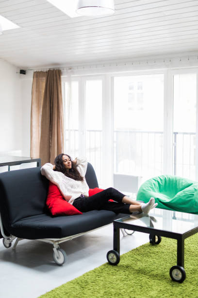 istock Young smiling woman lying relaxed on couch 1167938986