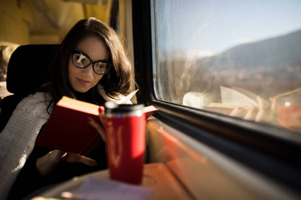 istock Woman reading while traveling with the train commuter journey sitting 1167943141