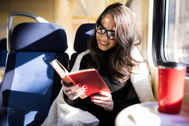 istock Woman reading while traveling with the train commuter journey sitting 1167943257