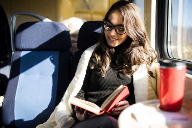 istock Woman reading while traveling with the train commuter journey sitting 1167944598