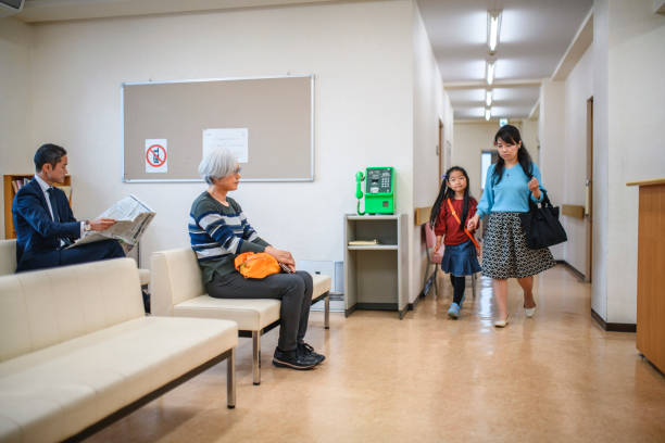 japanese mother and daughter entering patient waiting room - médico geral imagens e fotografias de stock