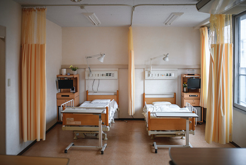 General view of Tokyo hospital room with two empty beds and lit by natural window light.