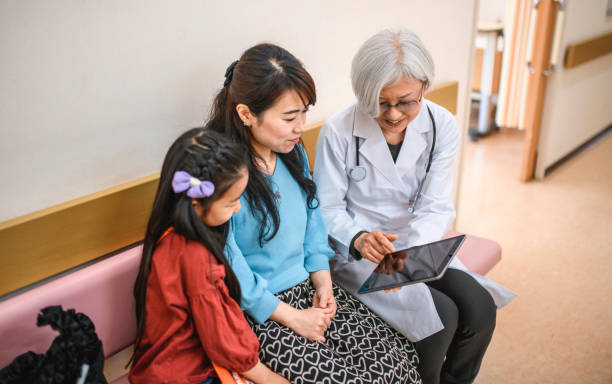docteur japonais féminin affichant la tablette numérique au patient - japan serious family senior adult photos et images de collection