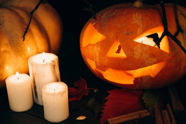 istock White candles stand before scarry Halloween pumpkin on cinnamon 1167945179