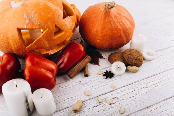 istock Scarry Halloween pumpkin stand on table with candles, cinnamon, red pepper and nuts 1167946029