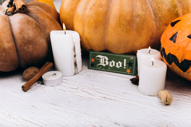 istock Card with lettering 'Boo' stands before scarry Halloween pumpkins 1167946093