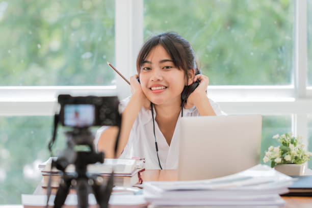 istock Happy Asian videoblog or student woman beauty blogger / vlogger recording tutorial coach presentation pass video for teaching live homework sharing online channel social media by mirrorless camera 1167946393