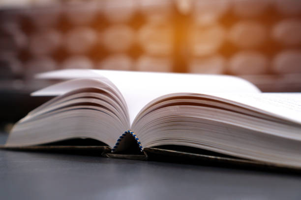 istock Open old textbook night light for reading in library or classroom on wooden lecture. copy space for text. Education for study learning in university concept. Classic tone, selective focus. 1167946479