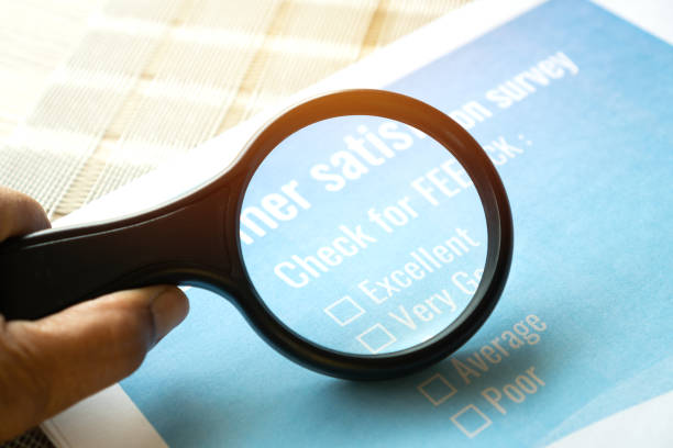Survey form feedback satisfaction concept: Customer use magnifying glass for checklist over application blue form document. Opinion question choice filling checkmark for business marketing research concepto de satisfacción de comentarios del formulario de encuesta: el uso del cliente de la lupa para la lista de verificación sobre el documento del formulario azul de la aplicación. elección de pregunta de opinión que llena la marca de verificació