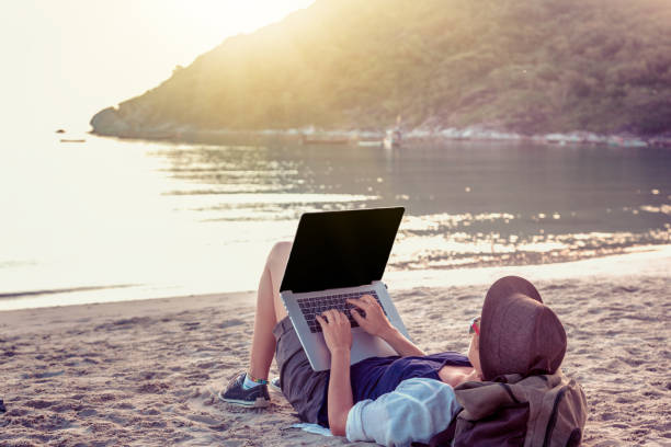 istock Young woman using laptop computer on a beach. Freelance work concept 1167947803