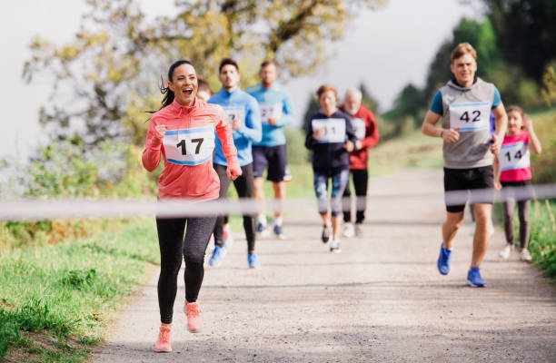 große gruppe von mehrgenerationen-menschen, die einen rennwettbewerb in der natur laufen. - running marathon jogging track event stock-fotos und bilder