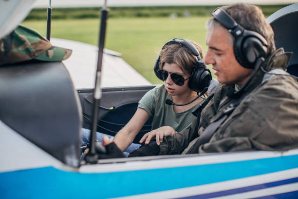istock Daughter and father pilot sitting in airplane 1167950096