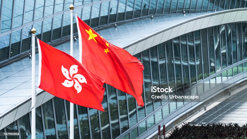 Hong Kong and mainland China national flags stand together with copy space. Nation symbol, countries political conflict concept Hong Kong Stock Photo