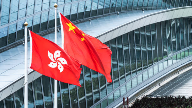 Hong Kong and mainland China national flags stand together with copy space. Nation symbol, countries political conflict concept stock photo