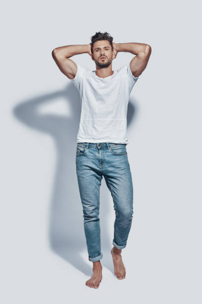 istock Full length of handsome young man looking at camera while standing against grey background 1167955223