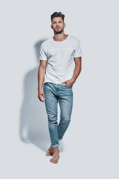 istock Full length of handsome young man looking at camera while standing against grey background 1167955420