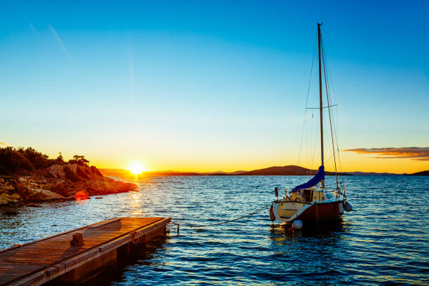 日の出時のヨット - yacht sea sunrise sailing ストックフォトと画像
