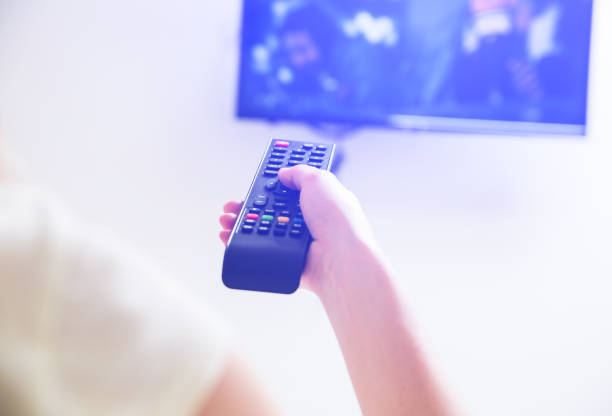 istock Woman is holding the remote control in her hands. Using TV at home. 1167956950