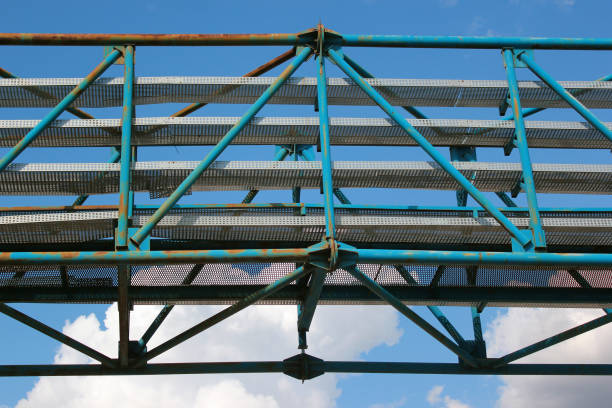 istock Old metal overhead pedestrian footbridge against blue sky 1167959907
