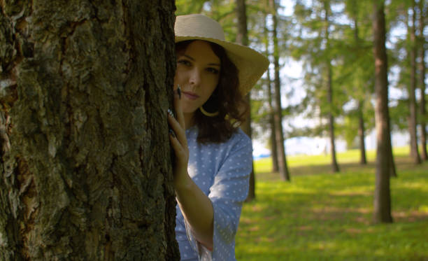 istock Young attractive woman standing near the tree 1167962015