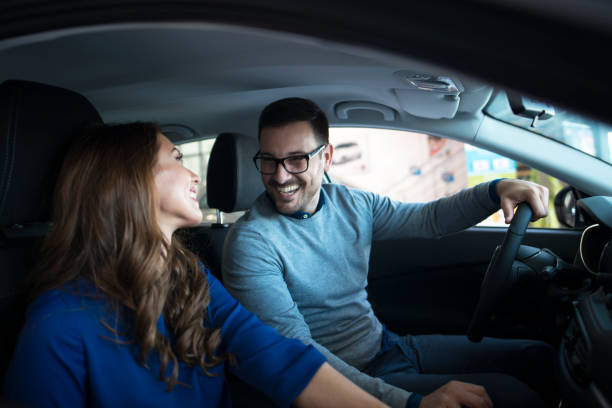 istock Happy smiling couple sitting inside the car looking at each other. 1167963168