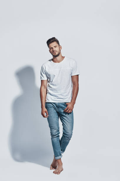 istock Full length of handsome young man looking at camera while standing against grey background 1167963180
