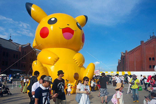 Yokohama, Kanagawa Prefecture, Japan - August 12, 2019: Pikachu Outbreak event at Red Brick Warehouse. A giant inflatable Pikachu displayed on the square. Many people from all over the world enjoy the event.