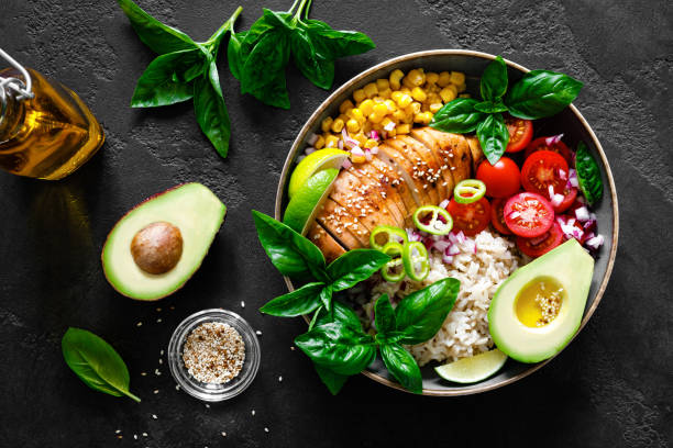 istock Grilled chicken breast lunch bowl with fresh tomato, avocado, corn, red onion, rice and basil 1167963920