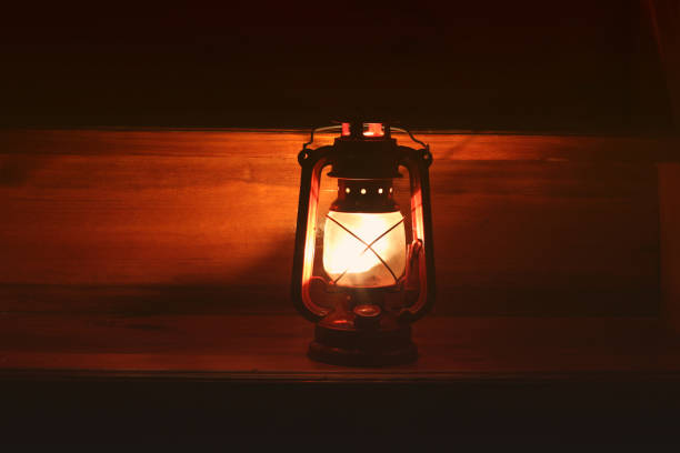 istock Kerosene lamp in the dark. Light on wooden background 1167965697