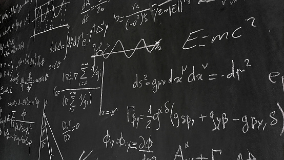 Various mathematical and physical formulas on a blackboard