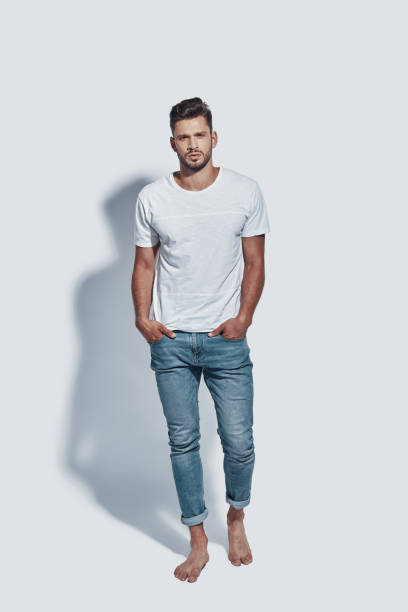 istock Full length of handsome young man looking at camera while standing against grey background 1167968231