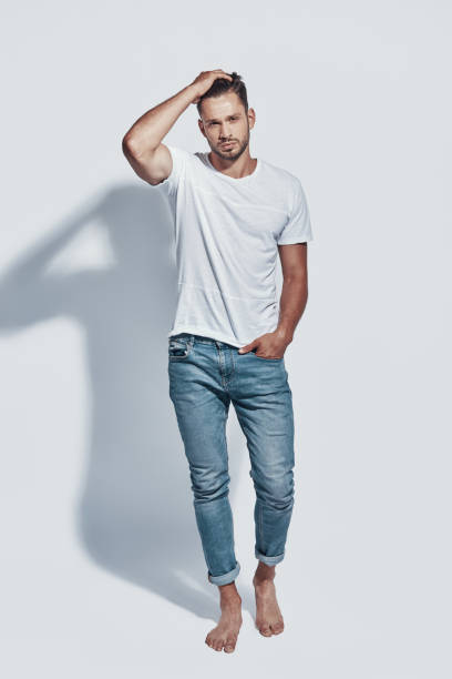 istock Full length of handsome young man looking at camera while standing against grey background 1167968302