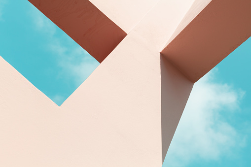 Abstract contemporary architecture, pink painted concrete structure under blue sky