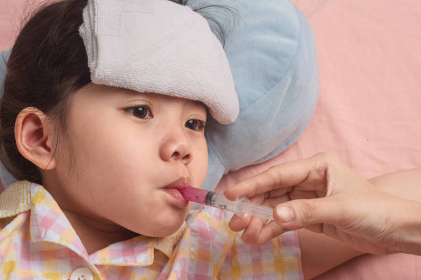 sick children from the flu while giving medicine. - primary care imagens e fotografias de stock