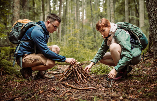 istock Campers lighting up fire to warm up themselves on cold rainy day in forest 1167971024