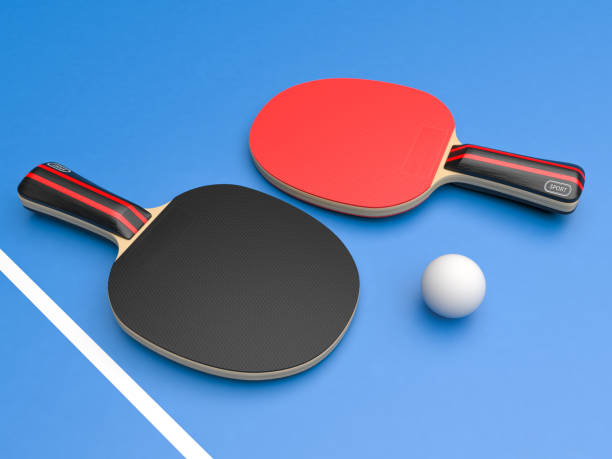istock Red and black table tennis rackets with ball. On blue background 1167971942