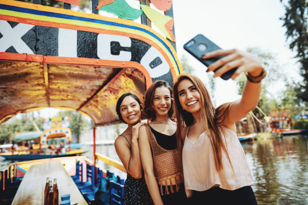 Millennial women in Mexico enjoying day in Xochimilco Gardens Mexican millennial women enjoying their lifestyles mexico city photos stock pictures, royalty-free photos & images