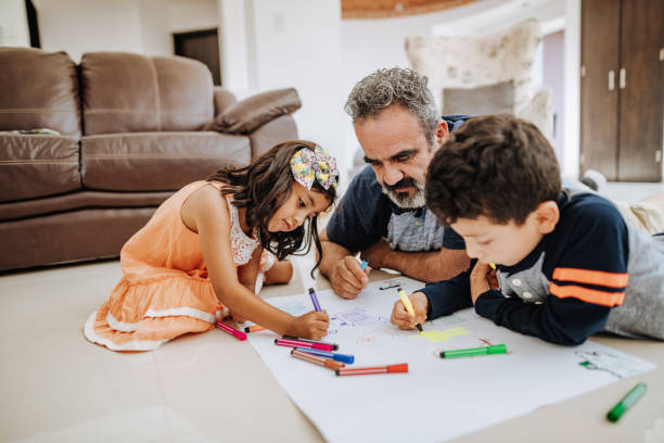 istock Creative Latin father drawing with children at home and laughing. 1167973956